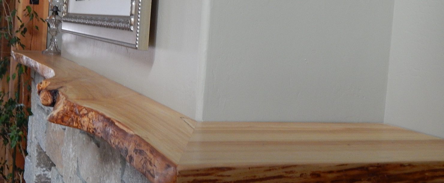 Live-edge birch mantel on a stone fireplace
